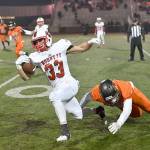 Paine Smith makes a quick getaway as a Monroe player makes a dive for him. The Mount Si Varsity Football team lost their first playoff match against Monroe High School in a close 44-40 game on Friday, Nov. 3. (Photo courtesy of Calder Productions)