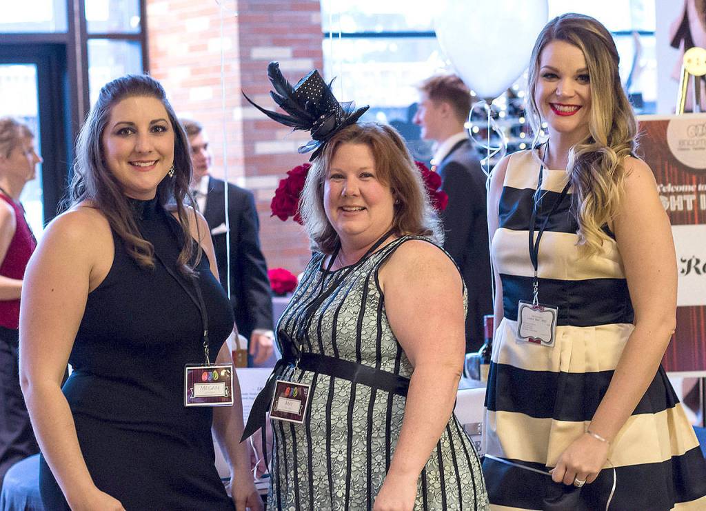 Encompass volunteers Megan Daniels, Amy Mogridge, and Lindsey Batz greet guests at the Oct. 21 gala. (Courtesy Photo)
