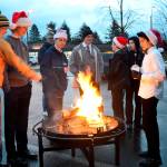 Friends gather around a fire pit for warmth in before the 2016 tree lighting. (File Photo)