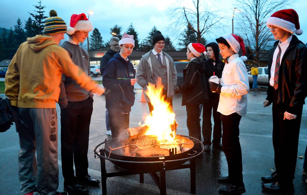 Friends gather around a fire pit for warmth in before the 2016 tree lighting. (File Photo)