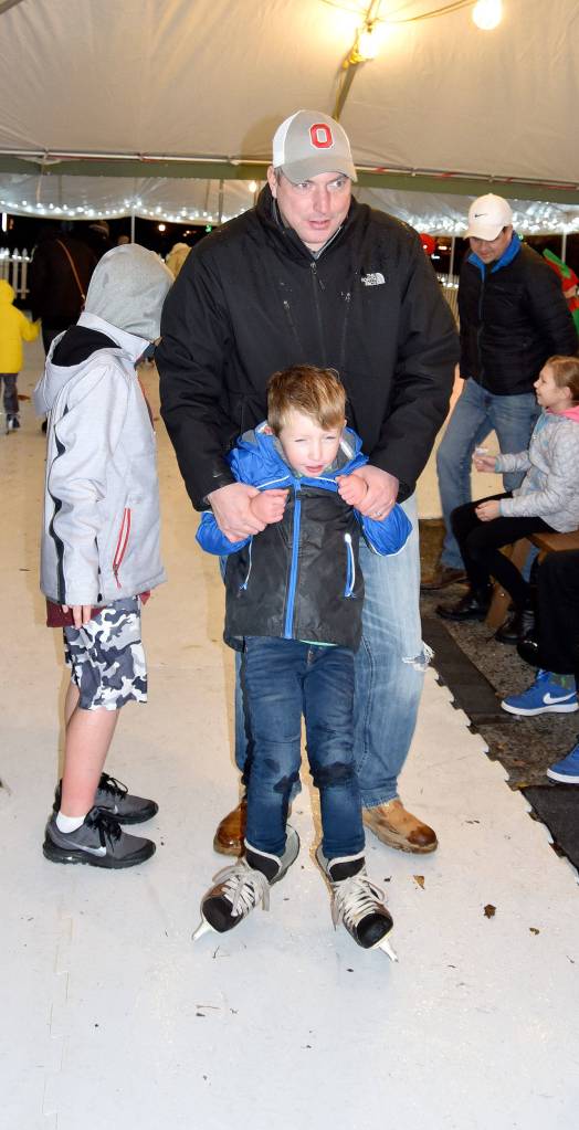 Far left: Chris Schniegenberg helps his son, Carter, balance on skates.                                Left above: Elves Eleanor Ward and Aeydan Liettla test out Snoqualmies skating rink Saturday, while they wait for their boss, Santa, to arrive.                                Left below: A growing crowd gathered around the Sno-Valley Winds performance Saturday evening at Snoqualmies holiday festival.                                 Staff photos by Carol Ladwig