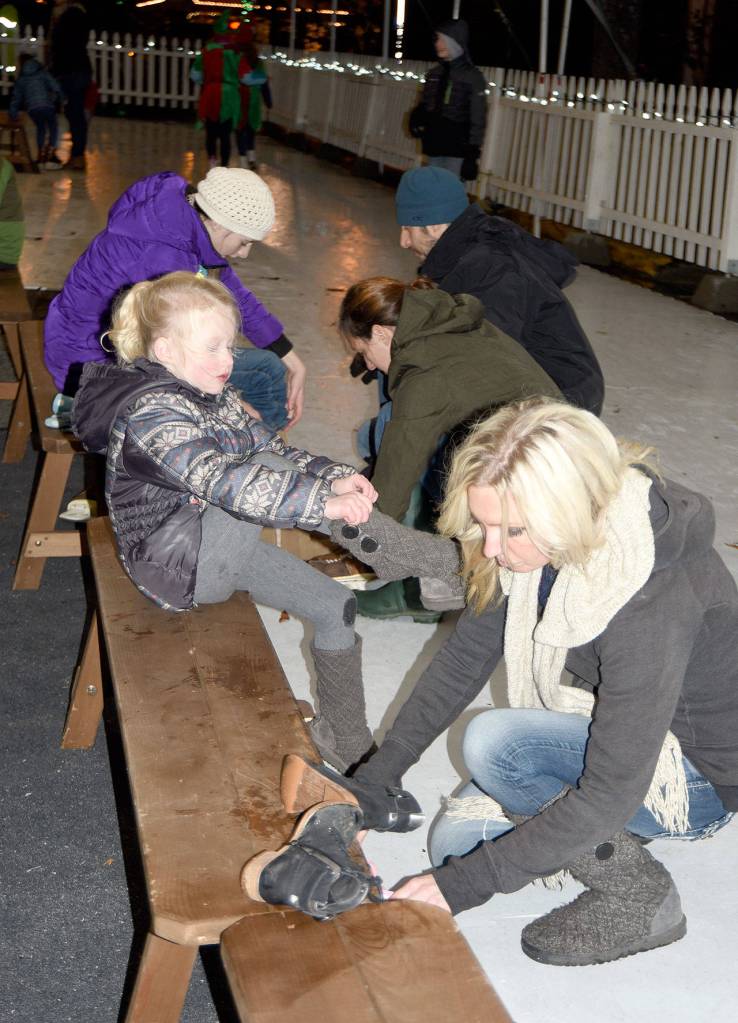 Shyloh, 5, and Dana Gottfried change back into their shoes after a pre-tree lighting skate in downtown Snoqualmie. (Carol Ladwig/Staff Photo)