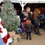 Santa sat with children and posed for photos in the gazebo at Railroad Park after the tree lighting. (Carol Ladwig/Staff Photo)