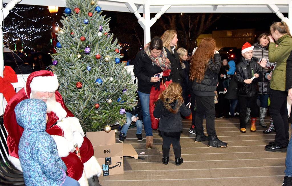 Santa sat with children and posed for photos in the gazebo at Railroad Park after the tree lighting. (Carol Ladwig/Staff Photo)