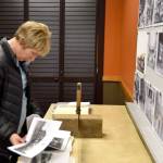 Sue Rovito takes a closer look at a scrapbook of photos. (Carol Ladwig/Staff Photo)