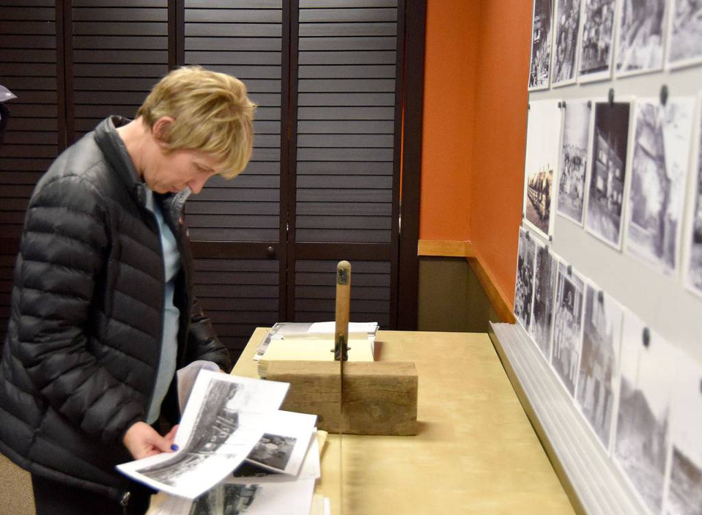 Sue Rovito takes a closer look at a scrapbook of photos. (Carol Ladwig/Staff Photo)