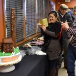 Cynthia Golpe, who baked the anniversary cake, photographs it before cutting and serving. (Carol Ladwig/Staff Photo)