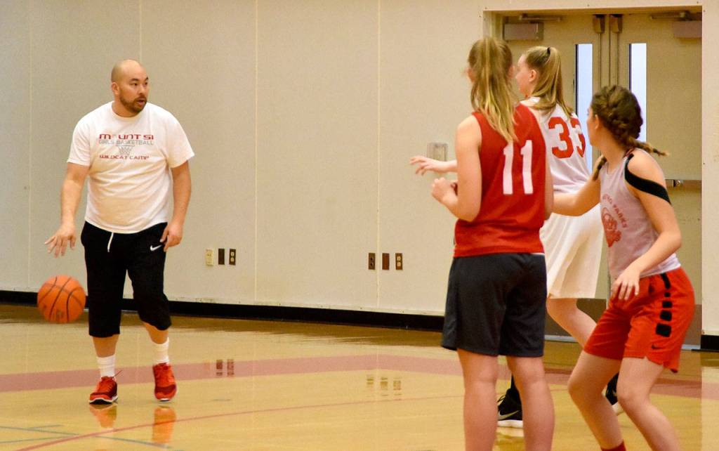 Coach Jason Marr dribbles the ball as he sets up a drill for the team to practice. (Carol Ladwig/Staff Photo)