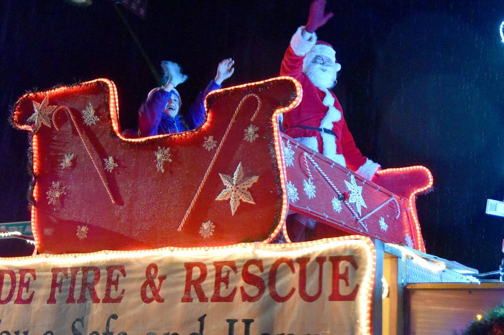 Santa and friends wave at Carnation residents from the Eastside Fire & Rescue Reindeer Engine, pulling into the Christmas in Carnation celebration Saturday evening. (Carol Ladwig/Staff Photo