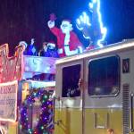 Santa and friends wave at Carnation residents from the Eastside Fire & Rescue Reindeer Engine, pulling into the Christmas in Carnation celebration Saturday evening. (Carol Ladwig/Staff Photo