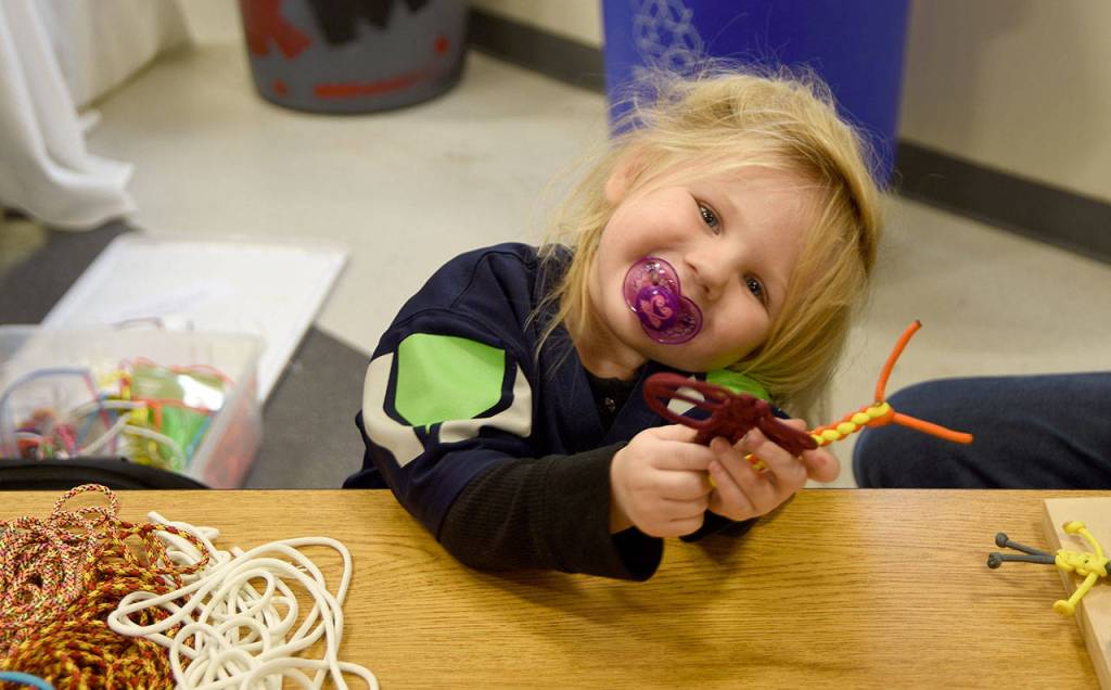 Presley Travis poses for a photo during her work staffing a booth at the Fall City holiday market. (Carol Ladwig/Staff Photo)