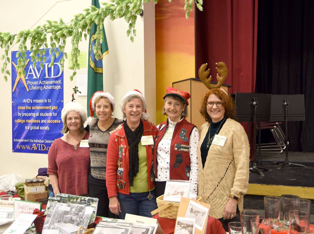 Fall City Historical Society members, from left, Leanne Adcox, Paula Spence, Cindy Parks, Donna Driver-Kummen, and Anne Neilson got in the spirit with holiday hats and an array of historical gifts for sale. (Carol Ladwig/Staff Photo)