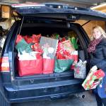 Tonya Guinn loads up her vehicle with holiday gifts for the teens who visit The Trail Youth each week. The group estimates they serve about 60 kids with their outreach. (Carol Ladwig/Staff Photo)