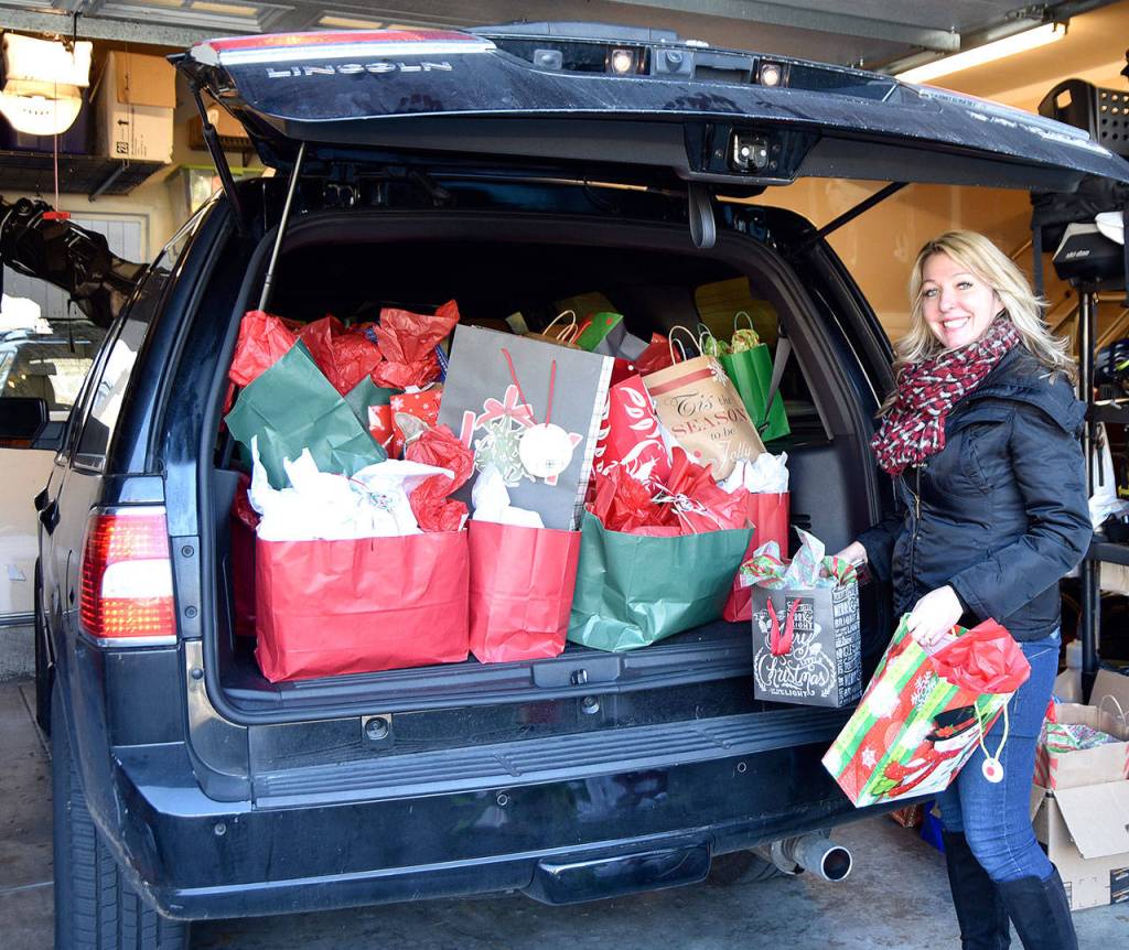 Tonya Guinn loads up her vehicle with holiday gifts for the teens who visit The Trail Youth each week. The group estimates they serve about 60 kids with their outreach. (Carol Ladwig/Staff Photo)