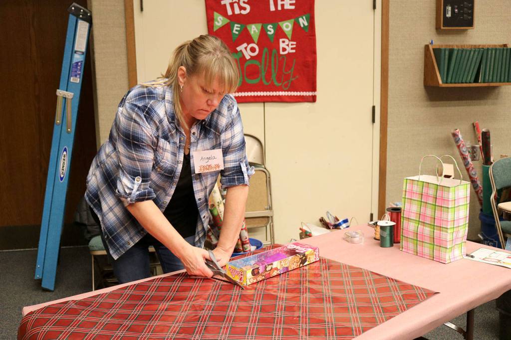 Angela Riley-Garcia wraps gifts at the Giving Tree shopping event. (Evan Pappas/Staff Photo)