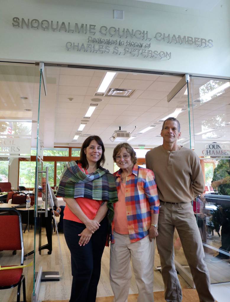 Carol Peterson, center, and her children Julie and Ryan stand in front of the newly unveiled name of the Snoqualmie City Council Chambers. (Evan Pappas/Staff Photo)