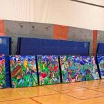 The seven individual wood panels that form the mural sit on the floor before being put up on the wall inside the gym. (Courtesy Photo)
