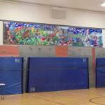 School district maintenance workers install the mural above the Opstad gyms rock wall on Dec. 28. (Courtesy Photo)