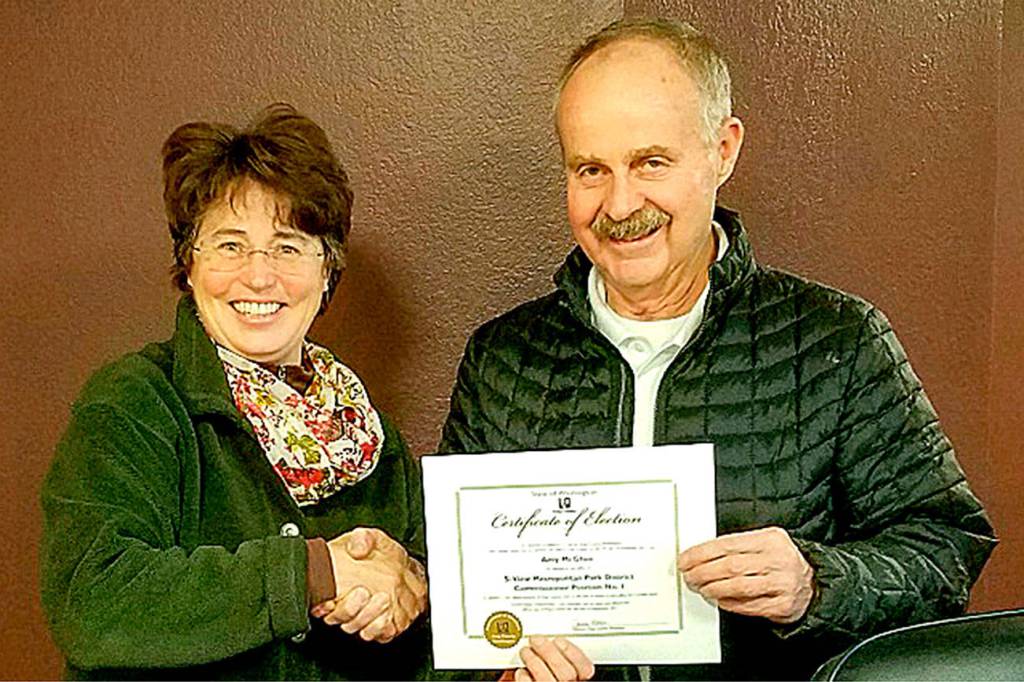 Amy McGhee is congratulated by Bud Raisio after shes sworn in for a second term on the Si View Metro Parks District board of commissioners Jan. 3. (Courtesy Photo)