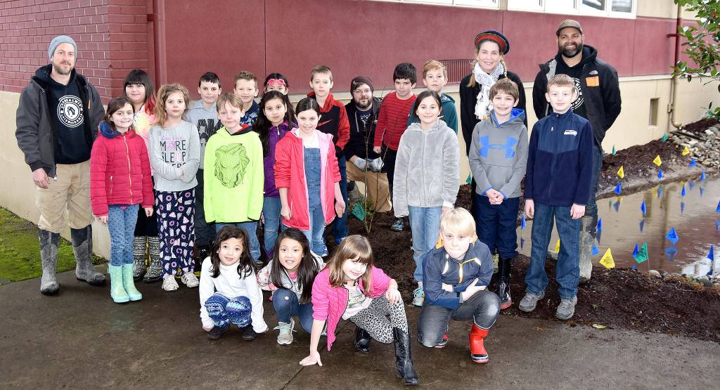 Carnation Elementary School third graders, and their teacher, Elizabeth Wing, commemorate their rain garden adventure with a group photo with Stewardship Partners staff. (Carol Ladwig/Staff Photo)