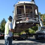 A crane lifts the donated electric car off the flatbed truck that hauled it from Petaluma, CA, and turns to set it on the flatbed train car that will take it to the Northwest Railway Museums conservation and restoration center. Men hold each corner by a rope so the car doesnt spin. (Carol Ladwig/Staff Photo)