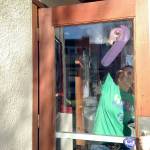 Relay for Life volunteer Sharon Piper paints the North Bend Theatres doors in 2015 as part of the fundraisers Paint the Valley purple campaign. (Record file photo)