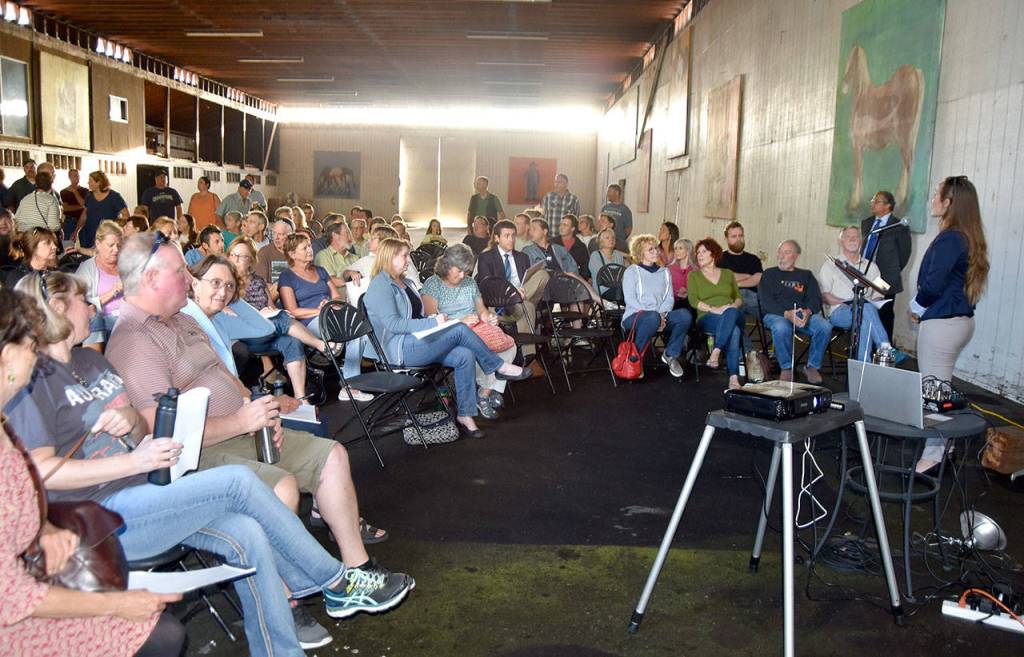 Alexis Hujar addresses the crowd of several hundred people at a community meeting about the future of Mountain Meadows Farm in August, which owner Chun Hou has proposed as the future site of an agricultural colleage. (Carol Ladwig/Staff Photo)