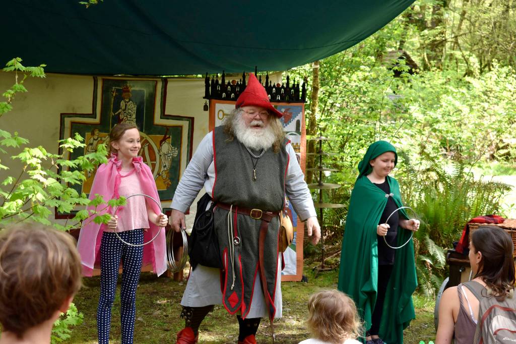 Two girls assist a magician with his tricks. Raechel Dawson/staff photo