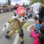 The Fall City Fire Departments mascot high fives a group of kids during the Fall City Day Parade. Evan Pappas/Staff Photo