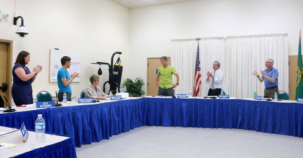 Council and staff give Jeanne Petterson a standing ovation after she concludes her reading of the song I Must Be Going. Evan Pappas/Staff Photo