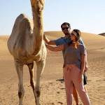 Jake and Madison Leland pet a camel in a desert near Dubai. Photo courtesy of Jake and Madison Leland