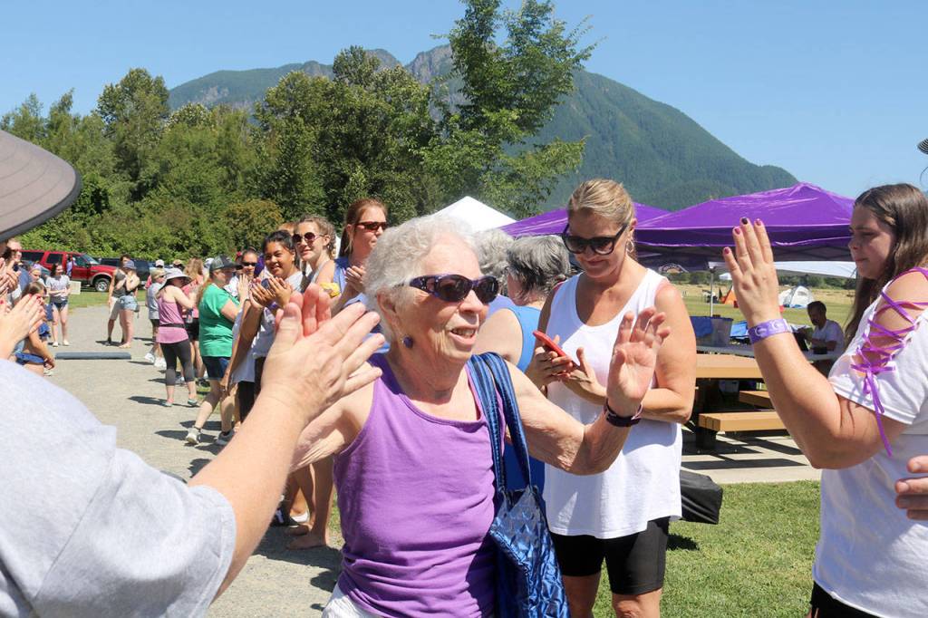 Beth Stewart, a 23-year cancer survivor, makes here way through the crowd getting high-fives from everyone in line. Evan Pappas/Staff Photo