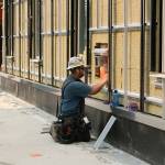 Construction worker installing siding to building. Madison Miller/staff photo.