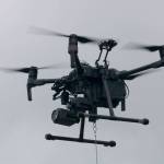 The DGI Matrice 210, equipped with two cameras, flies steady with a package of medical supplies hanging below by a rope. Evan Pappas/Staff Photo