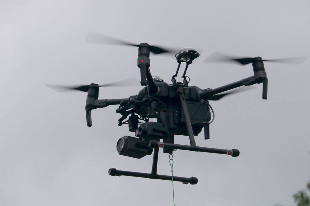 The DGI Matrice 210, equipped with two cameras, flies steady with a package of medical supplies hanging below by a rope. Evan Pappas/Staff Photo