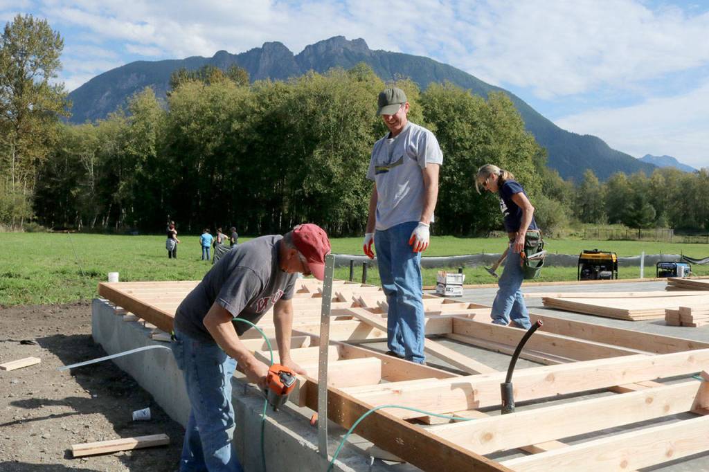SVYAC board member Byron Moore works with other volunteers on one of the walls. Evan Pappas/Staff Photo