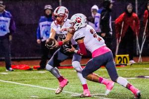 Mount Si Wildcats senior quarterback Cale Millen, left, hands off to running back Cole Norah in the first half of play. Norah had three rushing touchdowns in Mount Sis 38-6 victory against Issaquah on Oct. 5 at Gary Moore Stadium in Issaquah. Photo courtesy of Don Borin/Stop Action Photography