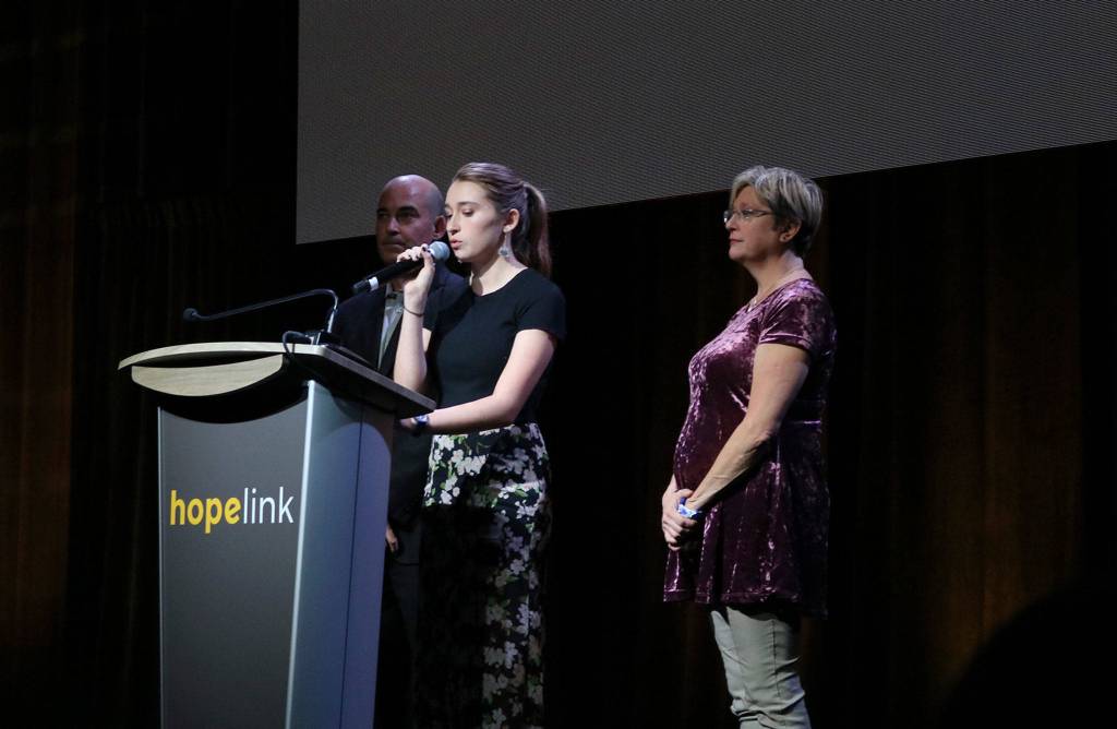 Zelda Shirk, a junior at Redmond High School, speaks at Hopelinks Reaching Out luncheon on Oct. 15 with her parents and event co-chairs, Jeff and Lynette Shirk. Katie Metzger/staff photo