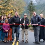 Tom Mohr, Ken Hearing, and Mark Rigos hold on to the ribbon along NE 12th Street, just outside of the Nursery at Mount Si. Evan Pappas/Staff Photo