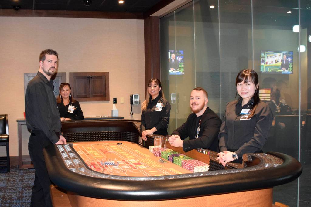 Snoqualmie Casino staff members (from left) Trevor House, Linda Yem, Sophorn Seng, Ross Garmon and Jan Wu surround a gaming table in the new private gaming room at Snoqualmie Casino. Photo courtesy of Tarah Smigun