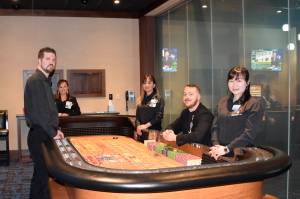 Snoqualmie Casino staff members (from left) Trevor House, Linda Yem, Sophorn Seng, Ross Garmon and Jan Wu surround a gaming table in the new private gaming room at Snoqualmie Casino. Photo courtesy of Tarah Smigun
