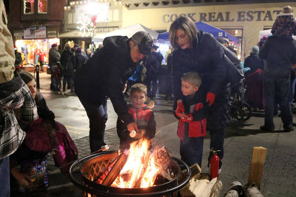 Brothers Chase and Nicky Iannuccilli roast marshmallows over one of the fire pits set up on North Bend Way at the citys Holly Days event. Evan Pappas/Staff Photo