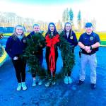 The 40-inch wreath was given to the Duvall Police Department for the third year in a row. From left: Elisabeth Anderson, Bethany Smith, Madison Rose, Emma Chaffin, Officer Cory Clark. Photo by Sarah Thomas