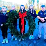 The 40-inch wreath was given to the Duvall Police Department for the third year in a row. From left: Elisabeth Anderson, Bethany Smith, Madison Rose, Emma Chaffin, Officer Cory Clark. Photo by Sarah Thomas