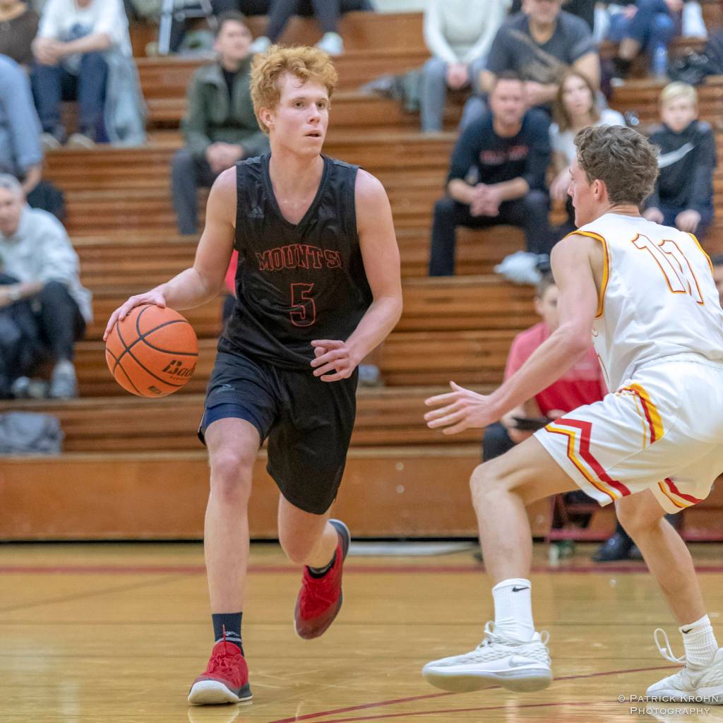 Mount Si junior guard Jabe Mullins, left, surveys the court while being defended by Newport senior Thomas Kristen. Mount Si defeated Newport, 66-44, on Dec. 14 at Newport High School in Factoria. Mullins scored 18 points in the win. Photo courtesy of Patrick Krohn/Patrick Krohn Photography