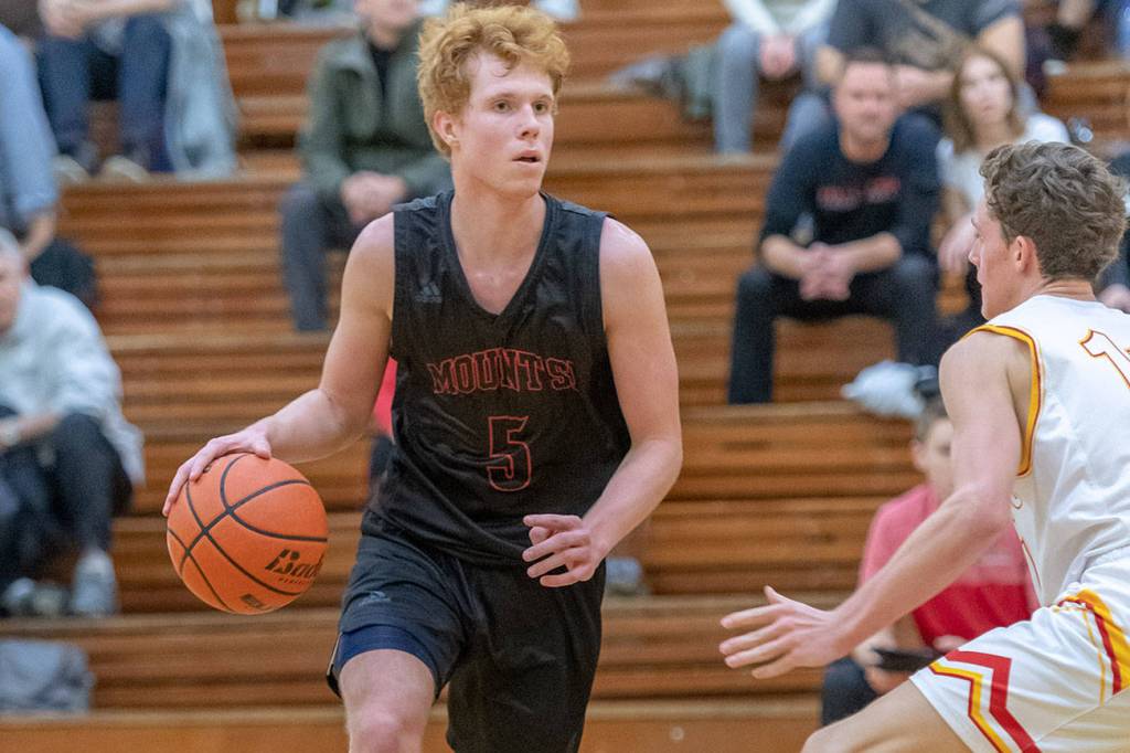 Mount Si junior guard Jabe Mullins, left, surveys the court while being defended by Newport senior Thomas Kristen. Mount Si defeated Newport, 66-44, on Dec. 14 at Newport High School in Factoria. Mullins scored 18 points in the win. Photo courtesy of Patrick Krohn/Patrick Krohn Photography