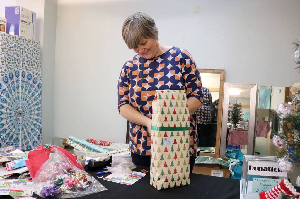 Lorraine Thurston of the Mount Si Band Boosters wraps gifts as part of a fundraiser to send the band on a trip to Pearl Harbor in April. Evan Pappas/Staff Photo