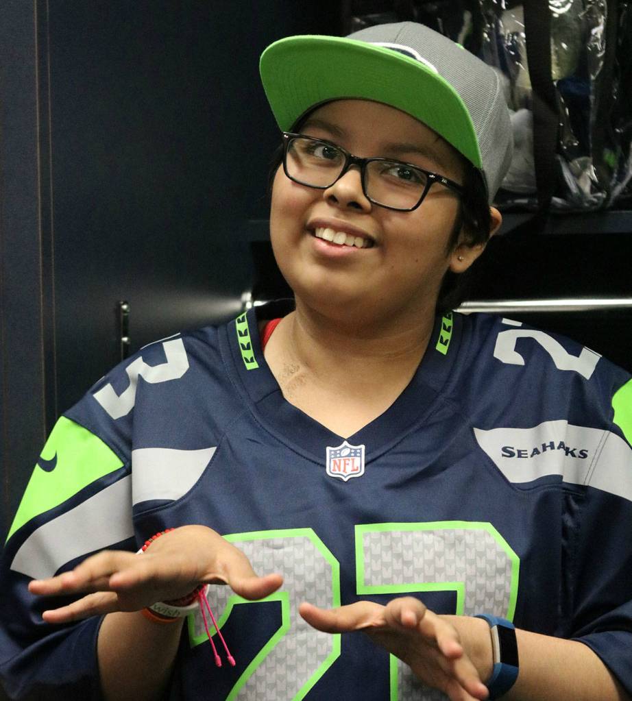 North Bends Paola Joaquin talks with family members in front of her personalized locker at CenturyLink Field in Seattle on Aug. 7. Andy Nystrom/Staff Photo