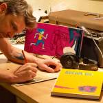 Josh Tuininga of North Bend sketches in his converted vintage Bluebird school bus art studio. Photo courtesy of Josh Tuininga