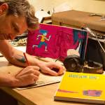 Josh Tuininga of North Bend sketches in his converted vintage Bluebird school bus art studio. Photo courtesy of Josh Tuininga